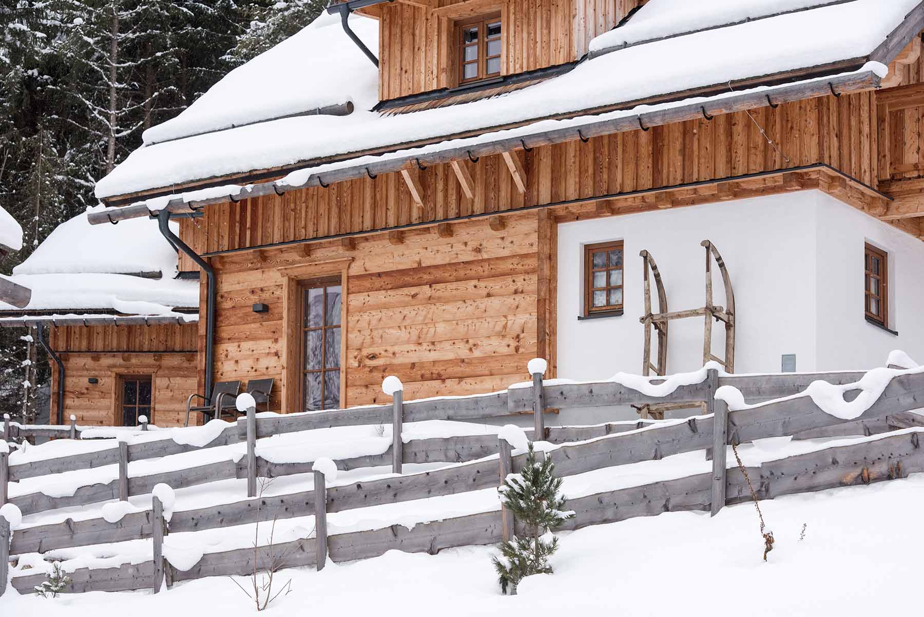Traditionelles Chalet im Bergdorf Donnersbachwald mit verschneitem Dach und Fassade aus alpinen Wandpaneelen Piz Buin in naturbelassener Optik.