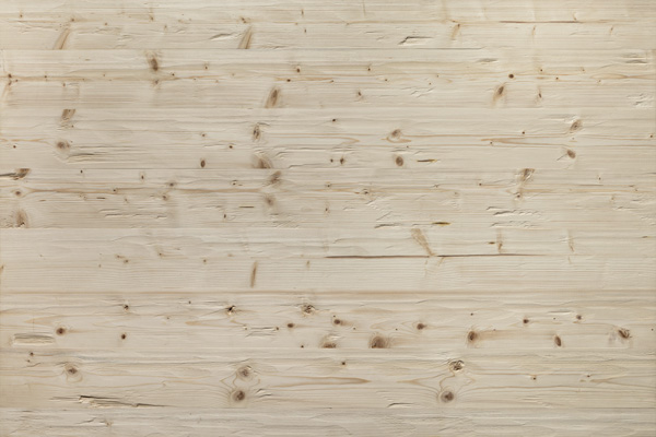 Nahaufnahme der gehackten Holzoberfläche Großglockner mit heller, lebendiger Struktur und ausgeprägter Maserung sowie Ästen in natürlicher Anordnung.