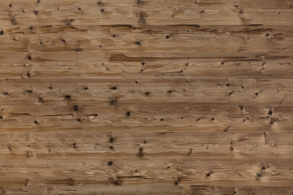 Mareiner Mont Blanc 212 Alpine Wandpaneele mit gehackter Oberfläche. Das Holz zeigt deutliche handgehackte Strukturen, markante Äste und ein lebendiges, rustikales Erscheinungsbild in warmen Brauntönen.