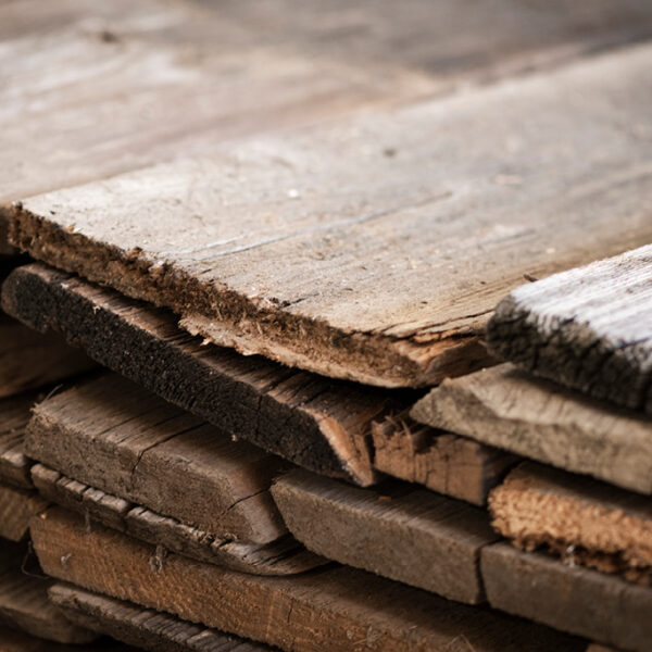 Close-up of weathered old wooden boards with a cracked, irregular structure and clear signs of wear.