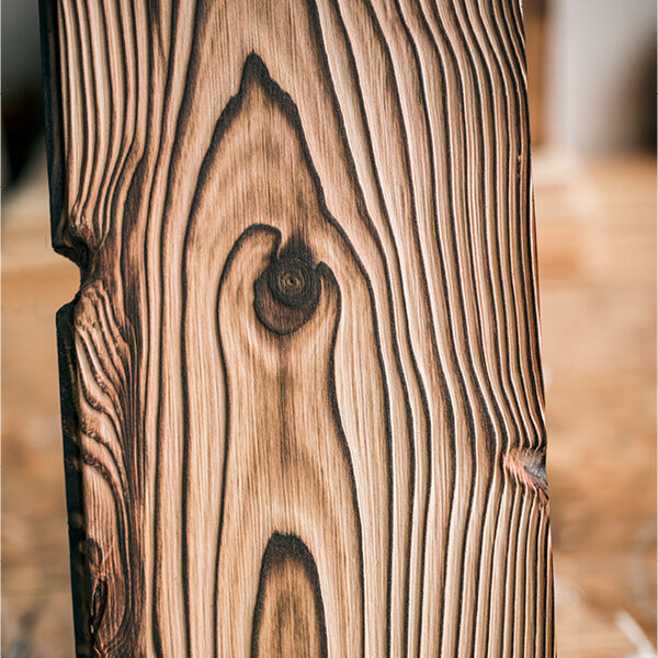 Close-up of a thermally treated wooden board with clear grain and dark grooves - natural structure and contrasts clearly visible.
