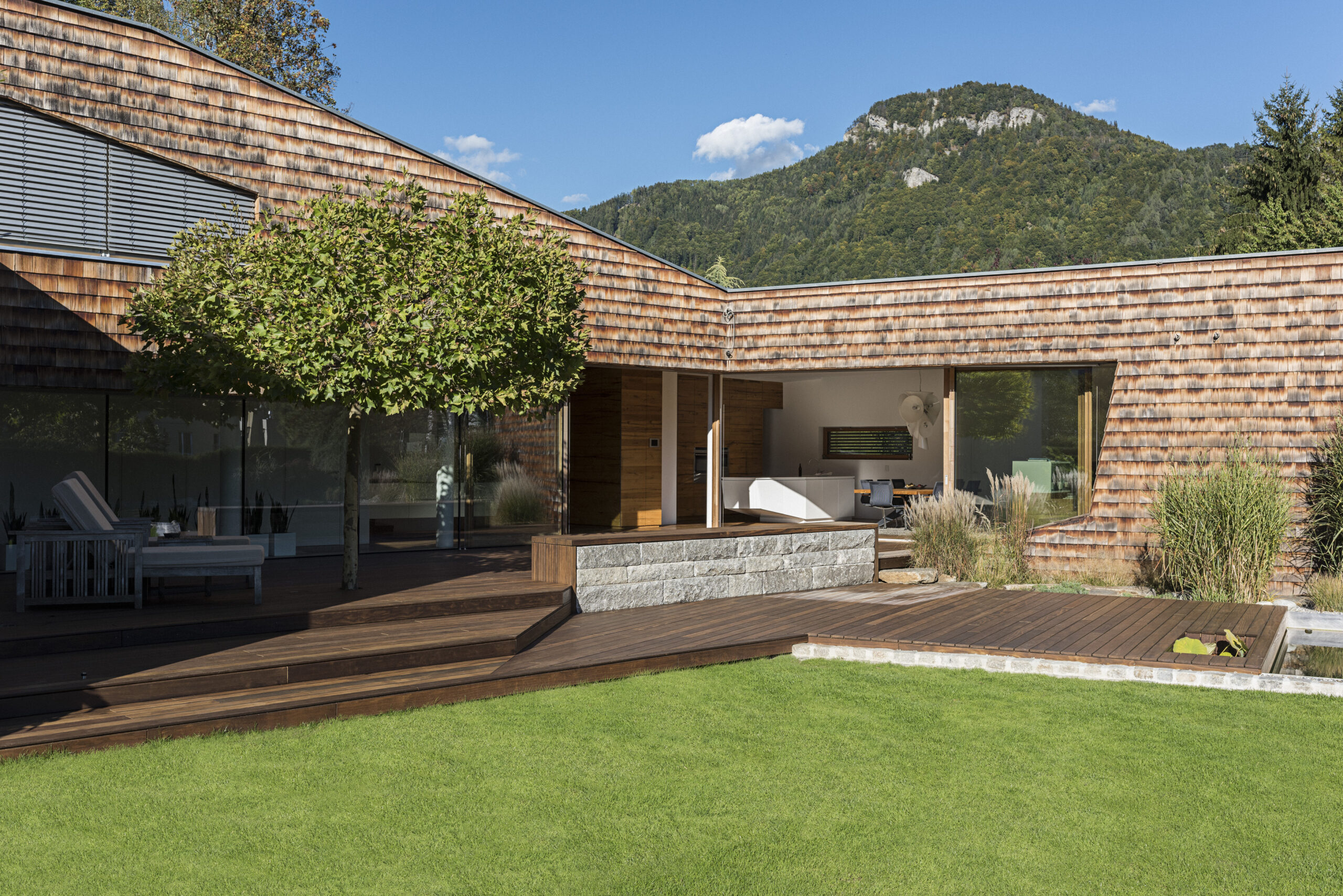 Nahaufnahme einer Holzterrasse mit feiner, natürlicher Maserung in elegantem Braunton. Die klare Linienführung der Dielen schafft ein harmonisches Gesamtbild mit stilvoller Optik.