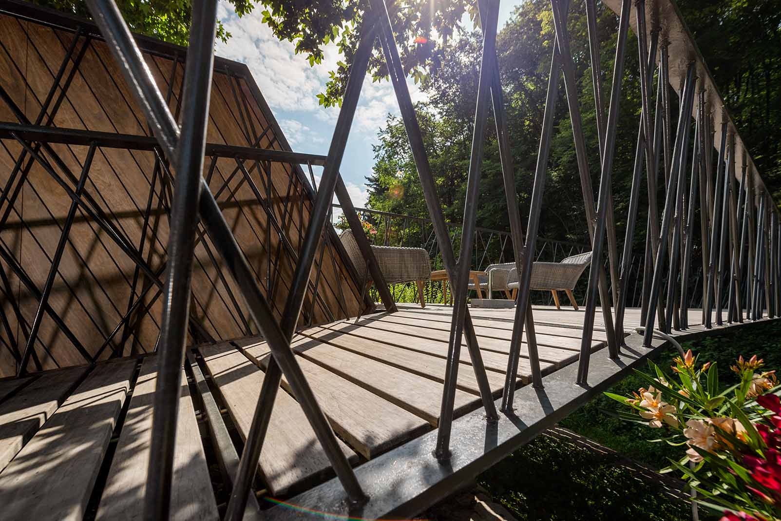 Detailansicht des Fußgängerstegs in Rosenburg mit Terrassendielen aus langlebigem Kebony-Holz. Die filigrane Stahlkonstruktion und das natürliche Holz fügen sich harmonisch in die grüne Umgebung ein.