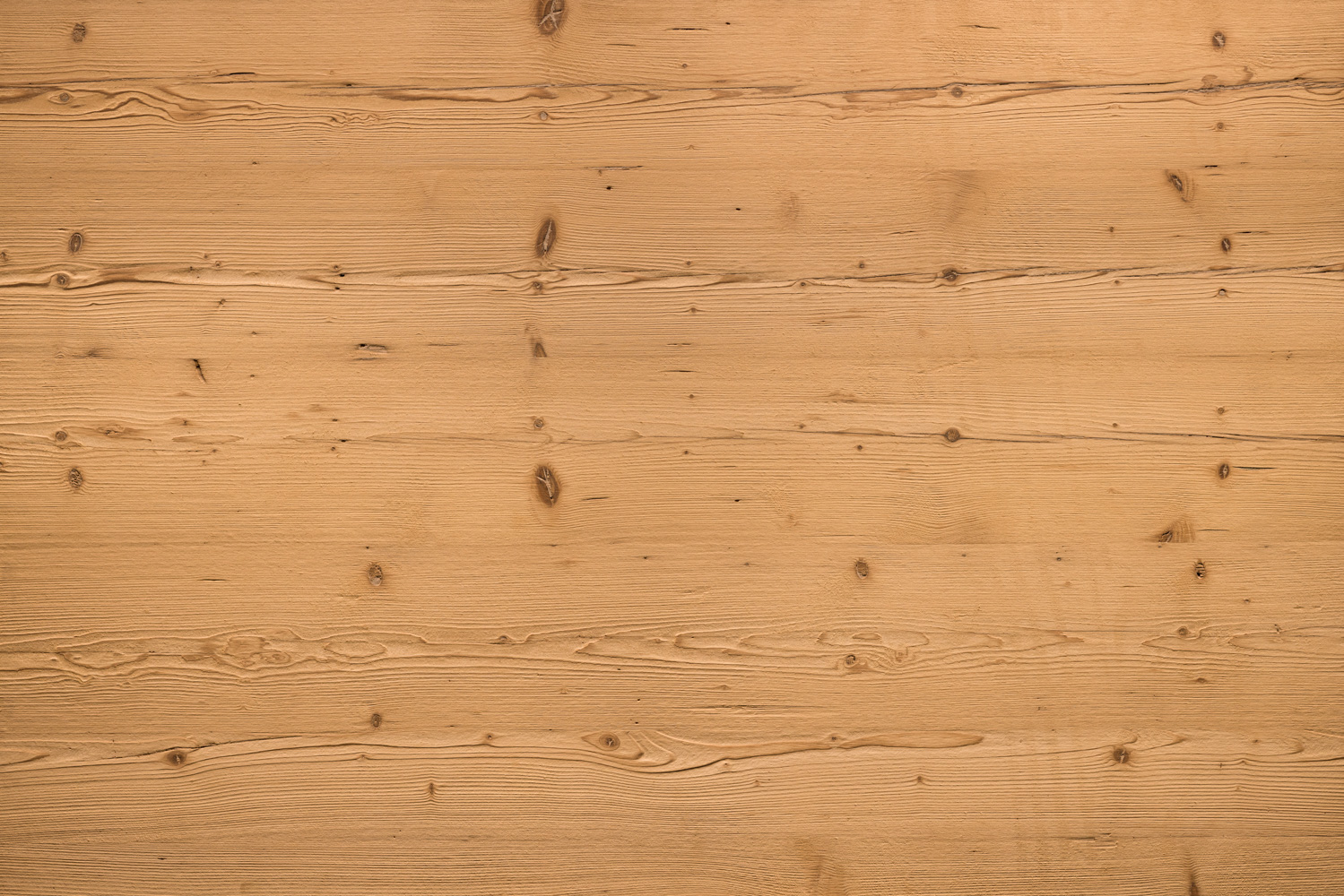 Holz mit gebürsteter Oberfläche. Gleichmäßige Textur mit Maserungen und kleinen Ästen. Die Oberfläche wirkt natürlich rau und hat einen hellen, warmen Braunton.