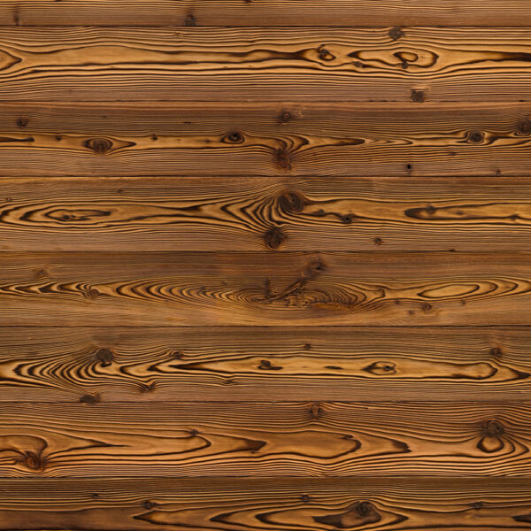 Flächige Holzoberfläche mit markanter, geflammter Optik. Die Bretter zeigen starke Kontraste zwischen hellen und dunklen Bereichen, typisch für gebranntes Holz. Ausdrucksstarke Maserung mit rustikalem Charakter für traditionelle oder moderne Akzente.