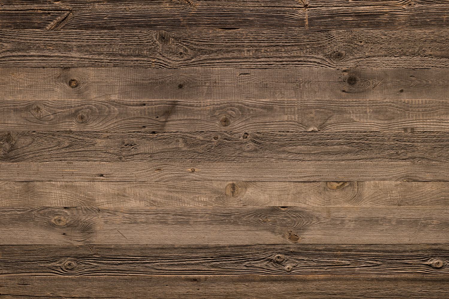 Grautoniges Altholz mit stark strukturierter Oberfläche, verwitterten Jahresringen und markanten Astlöchern. Die Patina vermittelt einen rustikalen, gealterten Charakter mit natürlicher Maserung und unregelmäßiger Färbung.