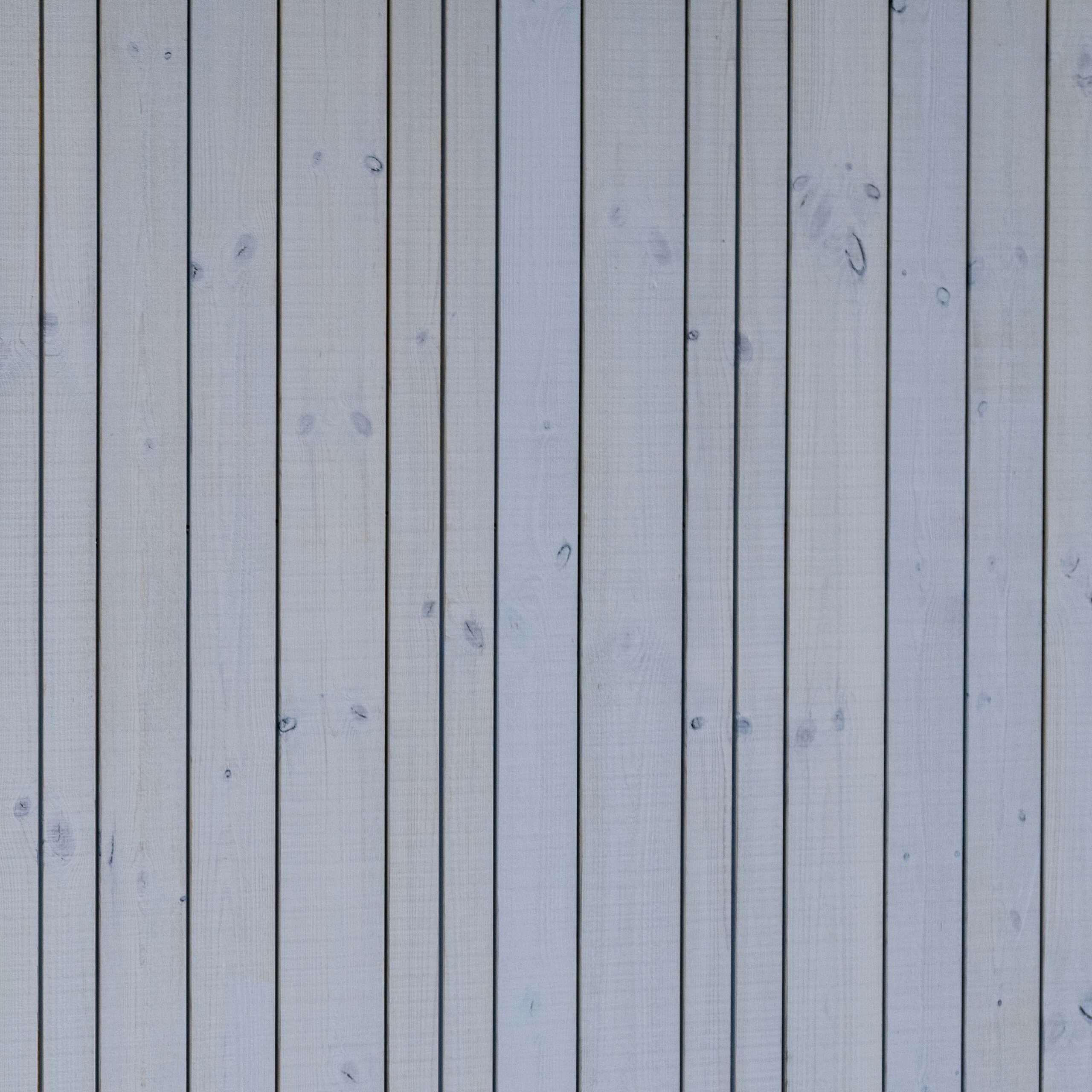 Detailaufnahme der senkrechten Holzfassade „Wörthersee beschichtet“ von Mareiner am Hotel Restaurant Krainer in Langenwang. Die hellgrau lasierten Bretter zeigen dezente Maserung und Astspuren und wirken modern und naturnah zugleich.